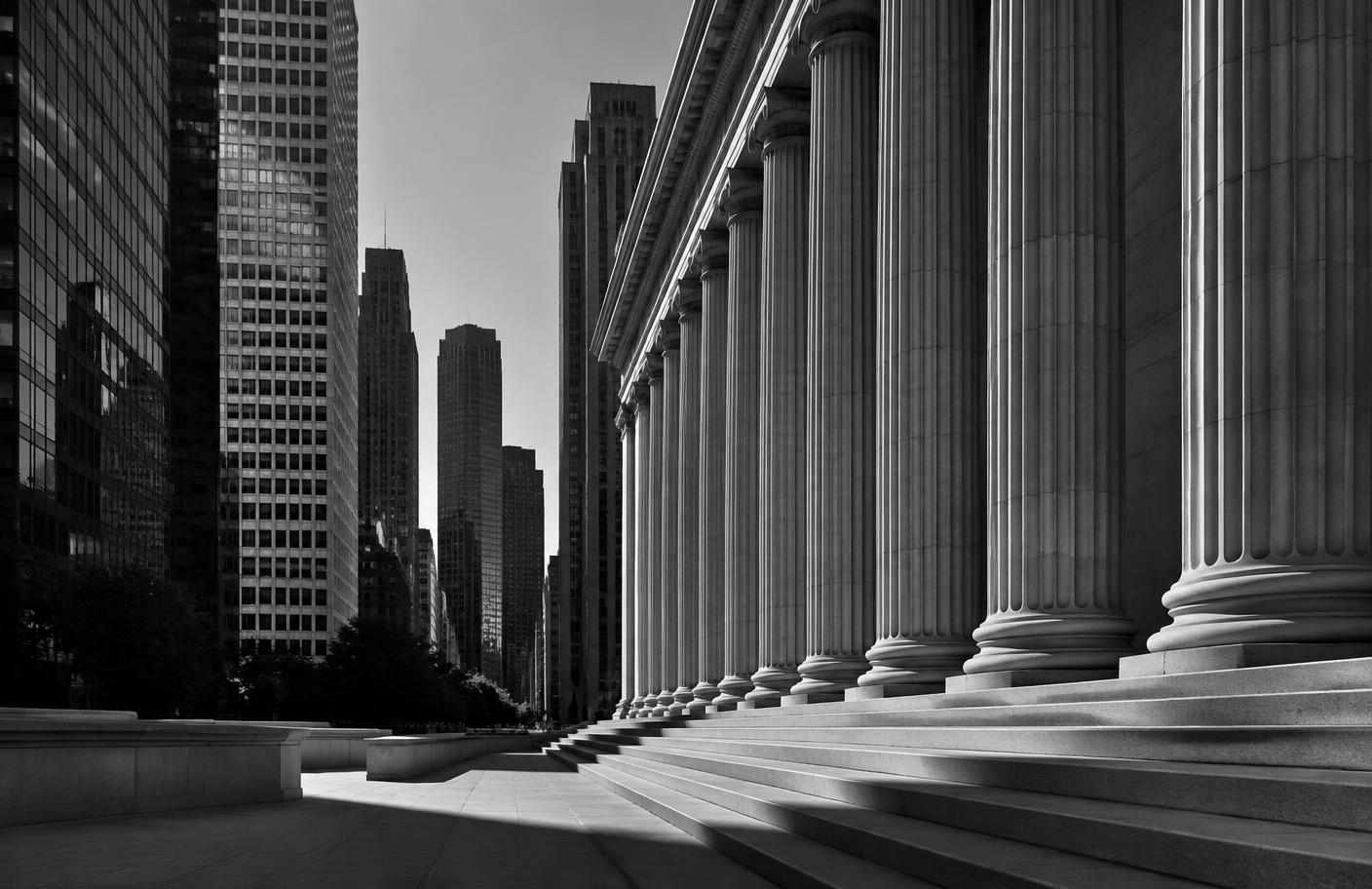 Institutional colonnade meeting a modern financial district